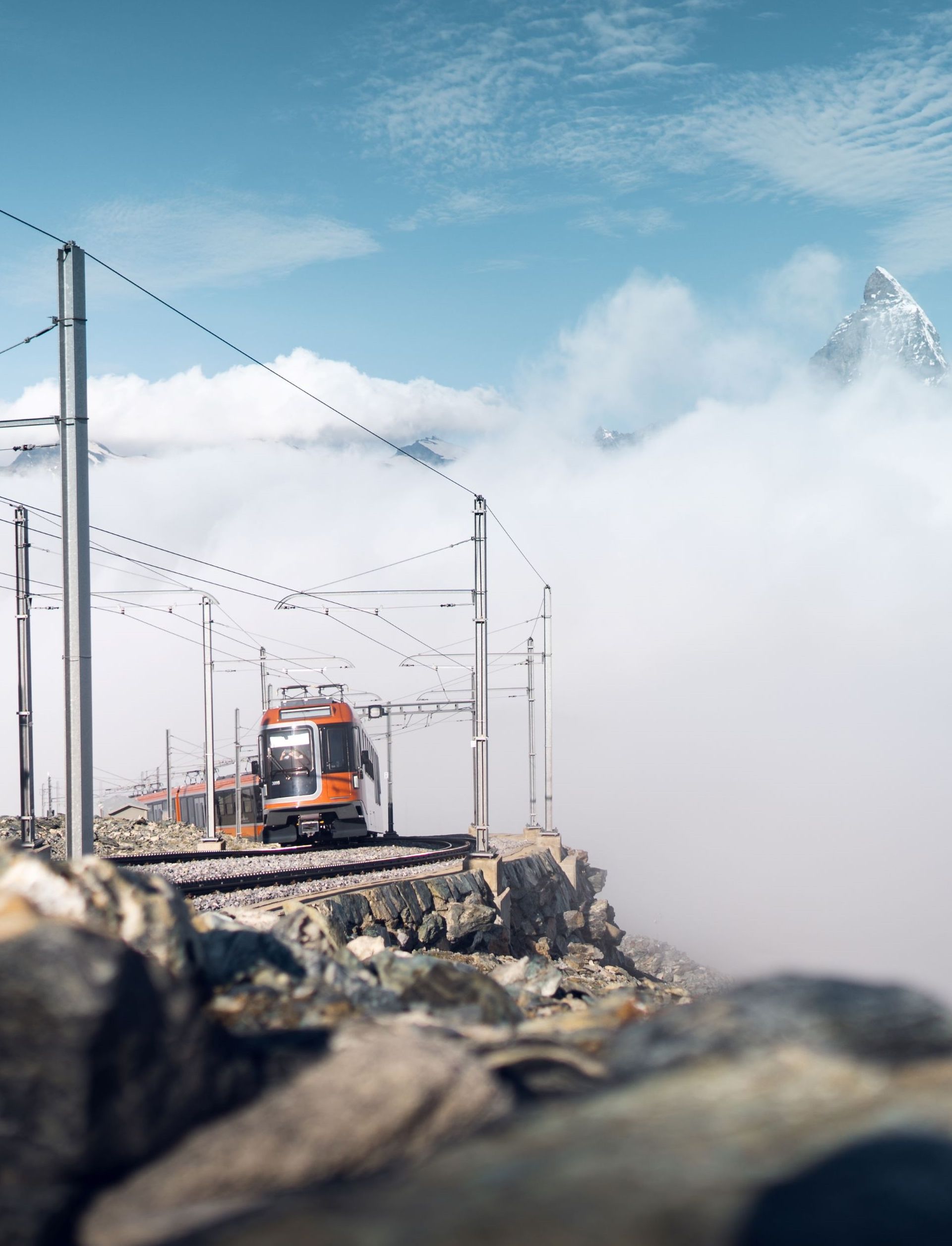 Le train Polaris émerge des nuages qui couvre une grande partie du Cervin, ne laissant apparaître que le sommet de la montagne.
