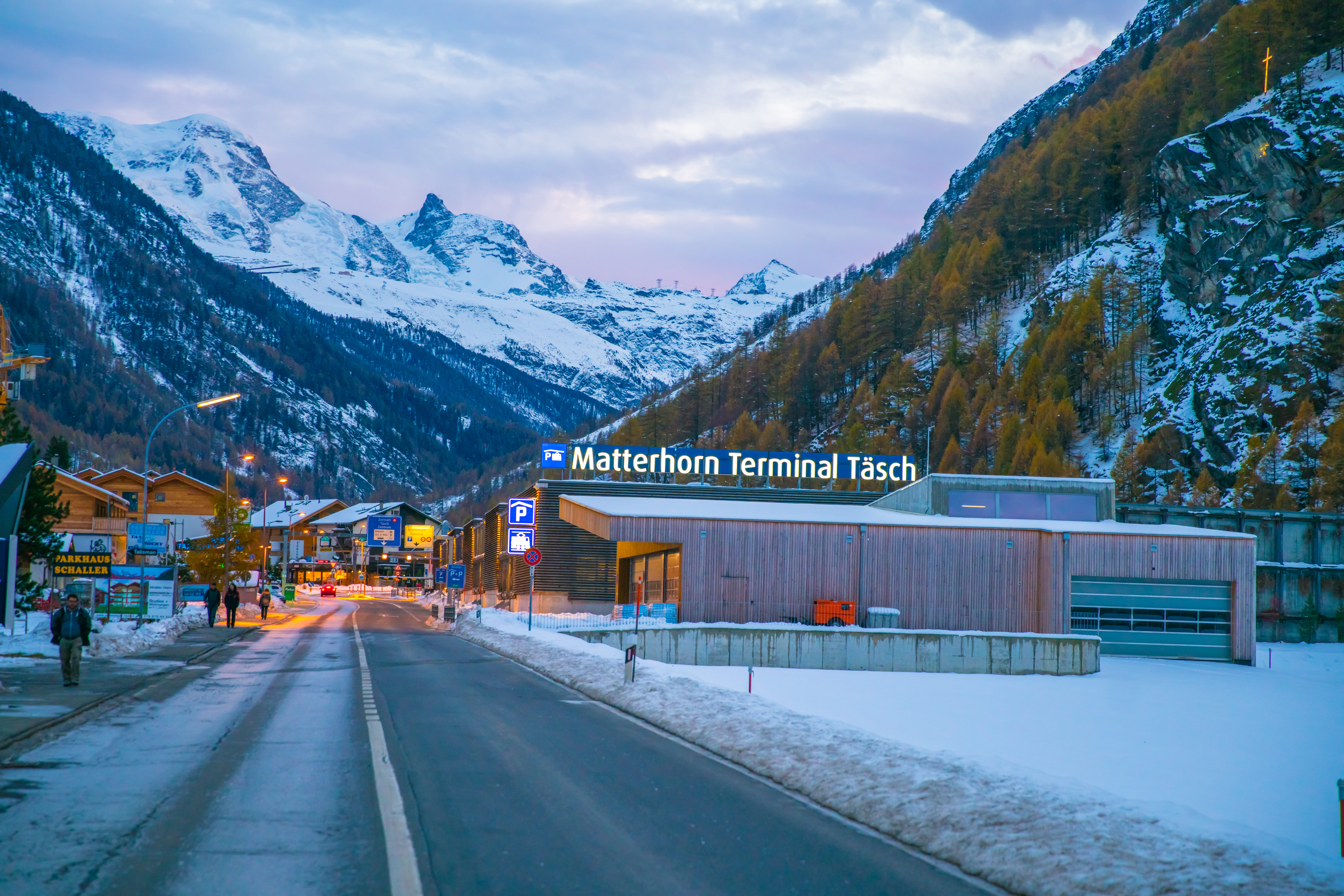 Der Matterhorn Terminal in Täsch am Ende des Tages im Winter, im Hintergrund die schneebedeckten Berge.