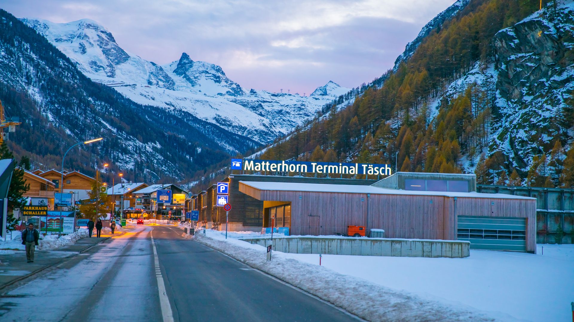 The Matterhorn Terminal in Täsch at the end of the day in winter, with the snow-capped mountains in the background.