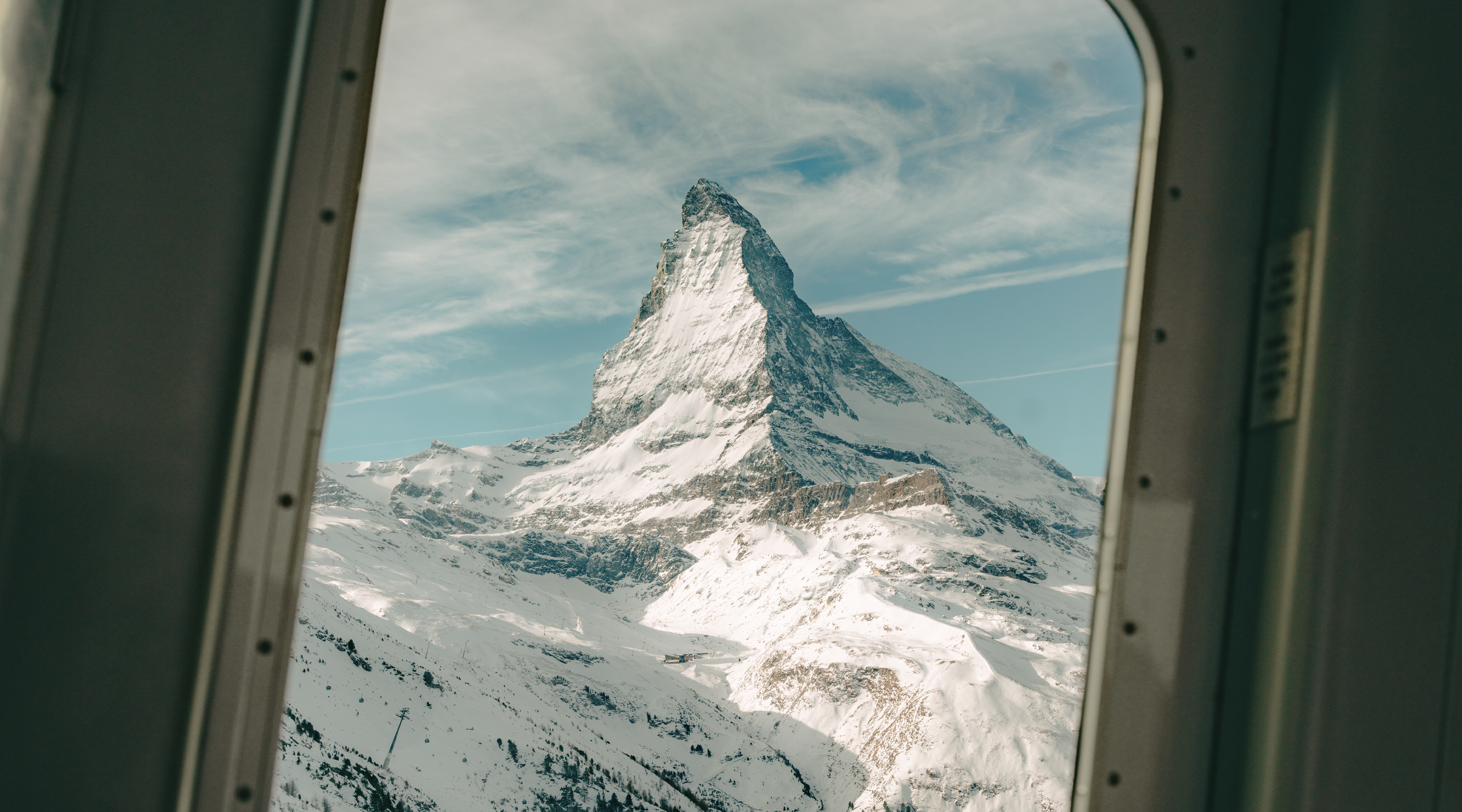 Aus dem NostalChic Class Wagen sieht man aus dem Fenster das Matterhorn in voller Pracht umgeben von Wolken.