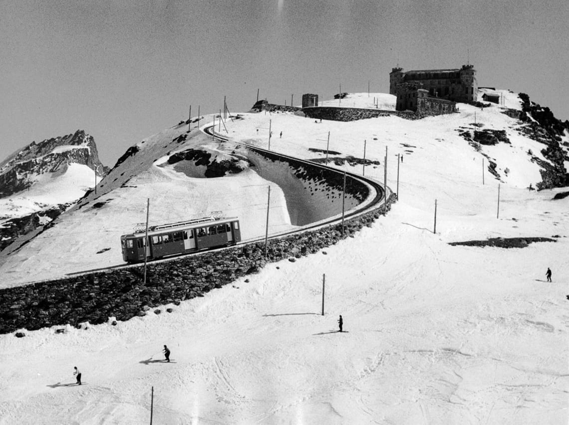 Skifahrer am Gornergrat in den 1940er Jahren mit der Gornergrat Bahn im Hintergrund, Zermatt, Schweiz