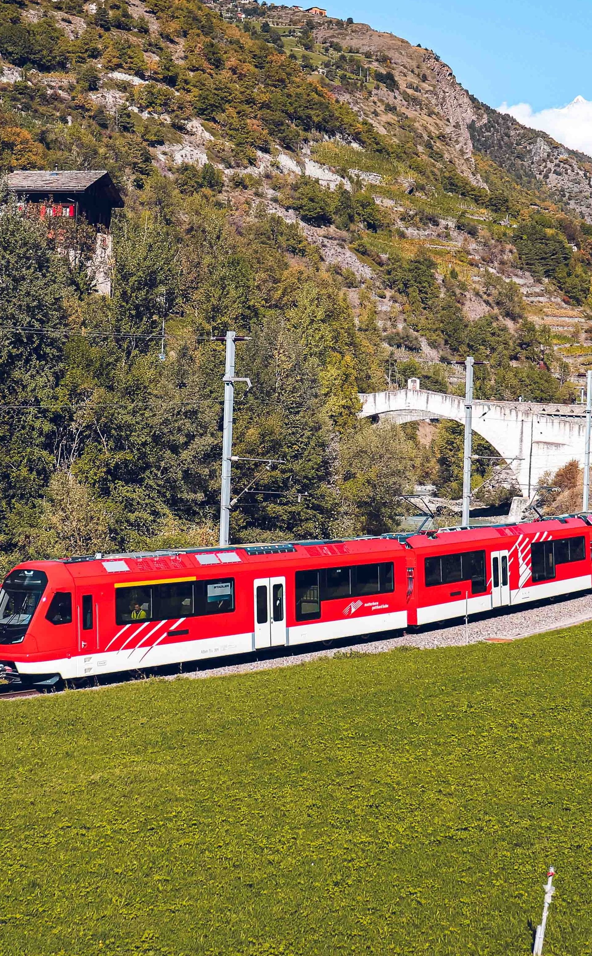 The Orion in the Mattertal valley in 2023, on a sunny day, crossing a green landscape.