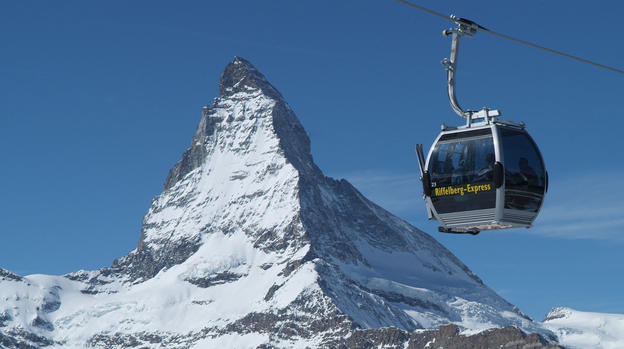The Riffelberg Express passes the Matterhorn on a sunny, cloudless winter's day.